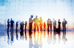 abstract photo of a light blue background with the silouette of people conducting business