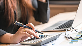 Closeup of a woman's hand working with an accountant calculator