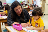 Teacher working with child on assignment