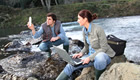 Two students engaging in research at a river